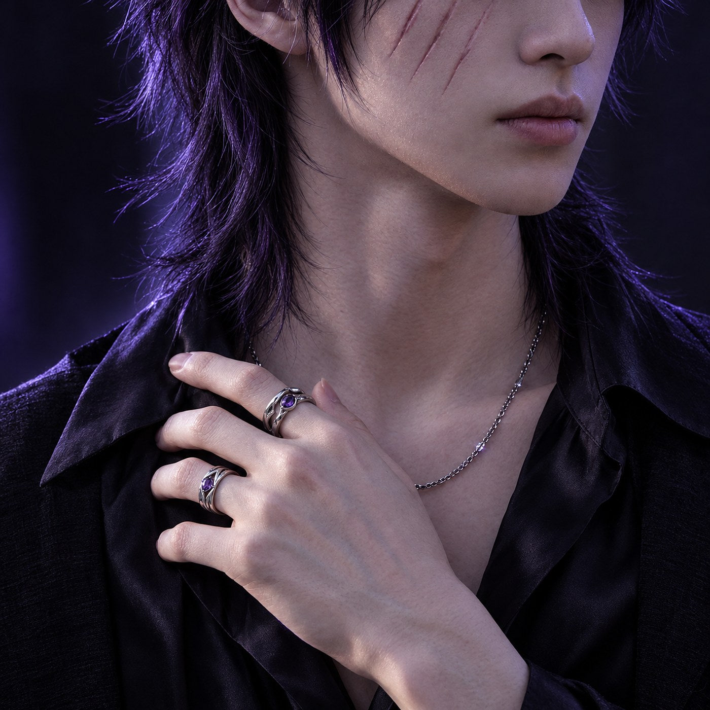 Close-up of hands with silver amethyst rings and fine chain